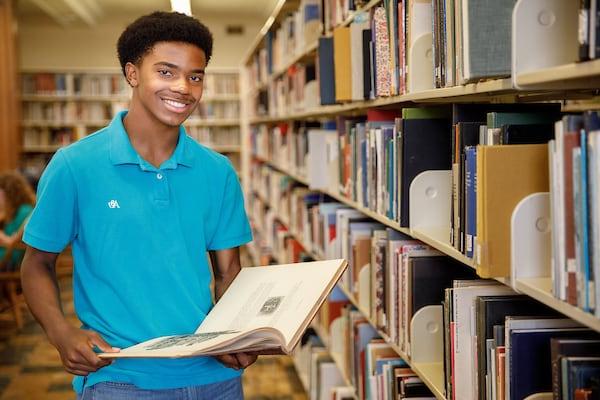 An early college student browses a library collection